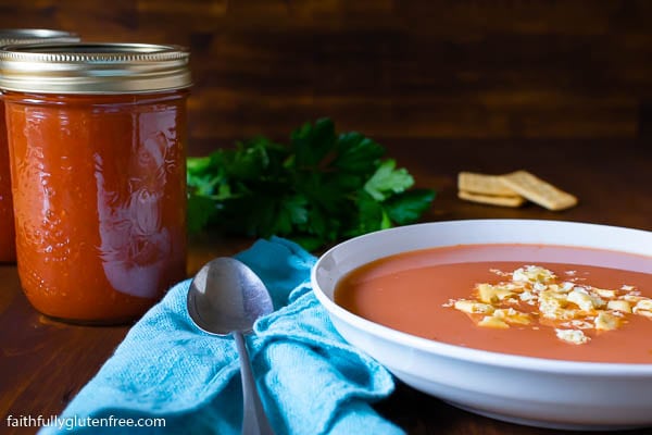 Bowl of tomato soup with a jar of tomato soup beside