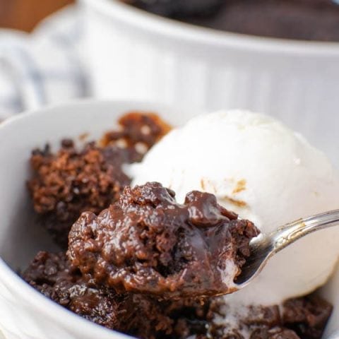 a bowl of chocolate pudding cake with a scoop of vanilla ice cream