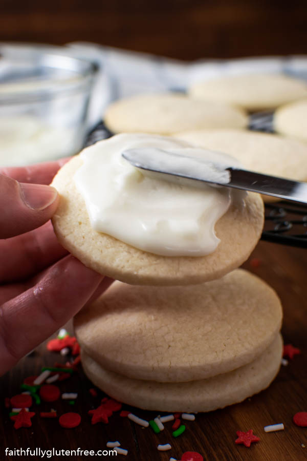 Icing being spread on a sugar cookie