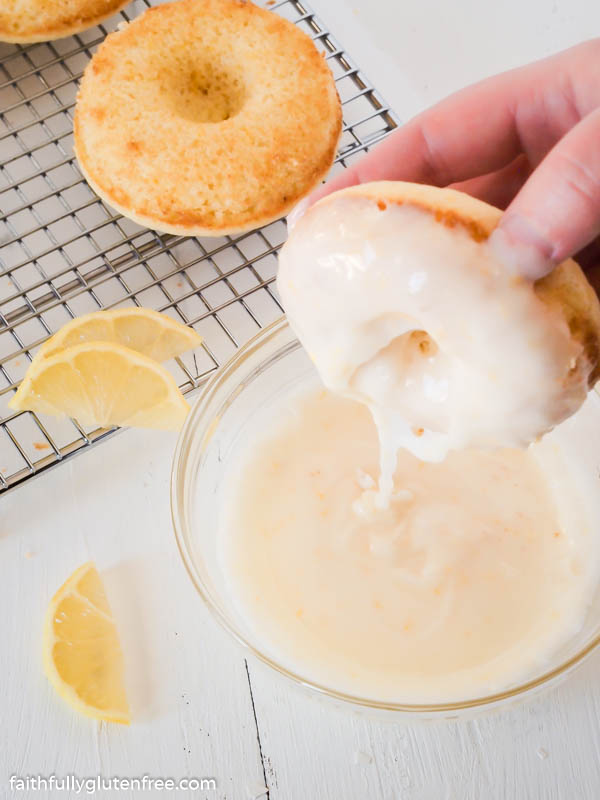 Dipping lemon donut in glaze
