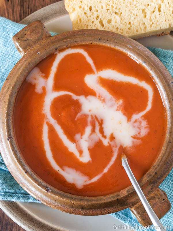 A bowl of creamy tomato soup drizzled with milk