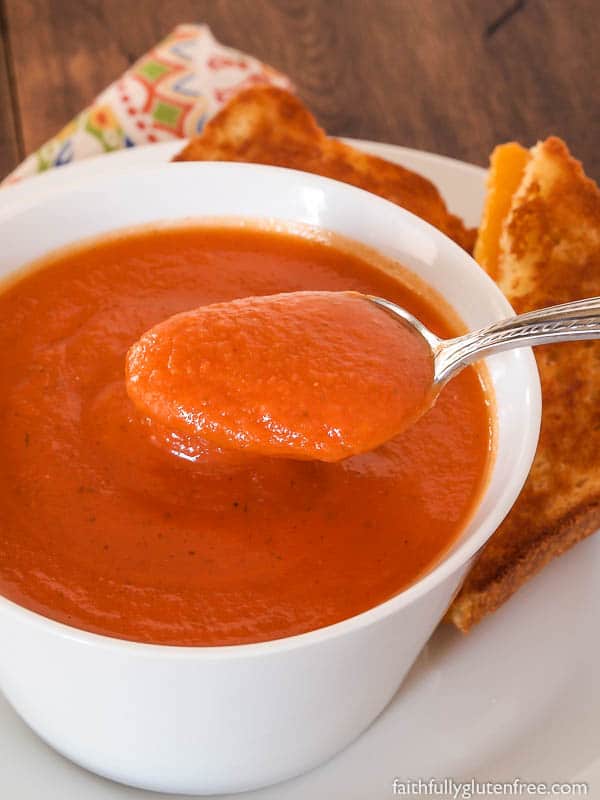 A spoon in a bowl of creamy dairy free tomato soup