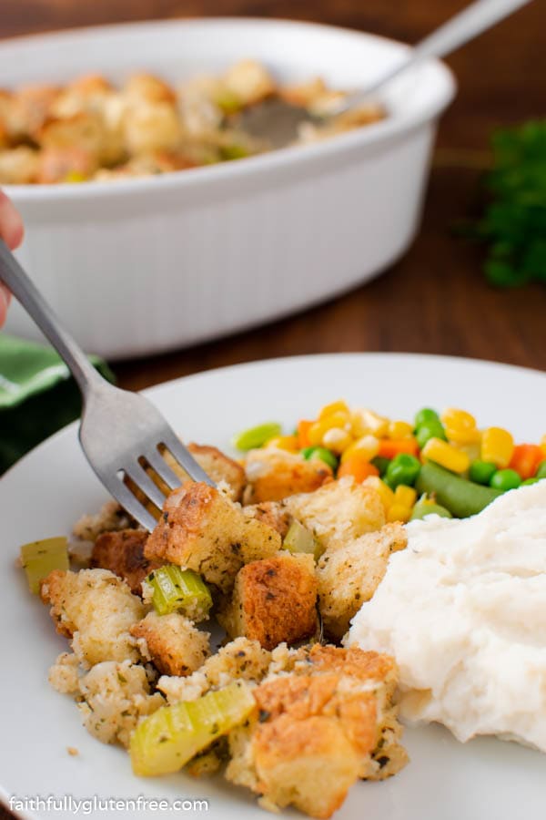 A plate with bread stuffing, mashed potatoes and mixed vegetables