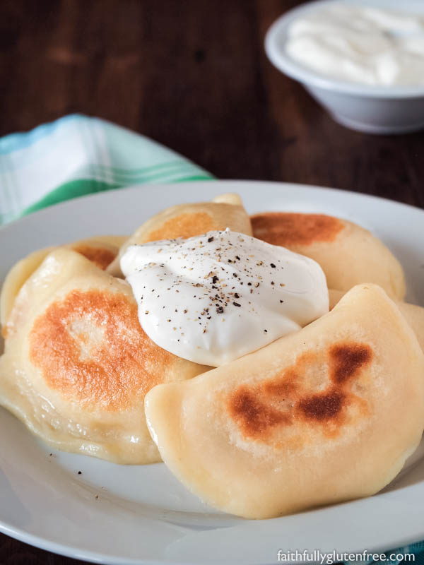 Plate of fried gf Perogies (Pierogi) topped with sour cream