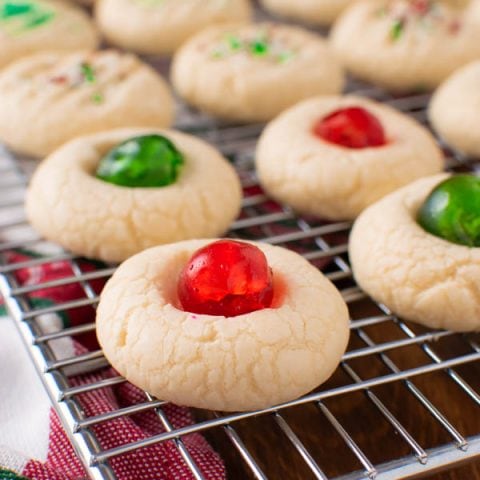 A tray of whipped shortbread cookies with cherries