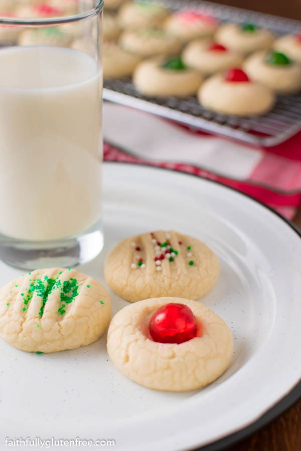 a white plate with whipped shortbread cookies and a glass of milk