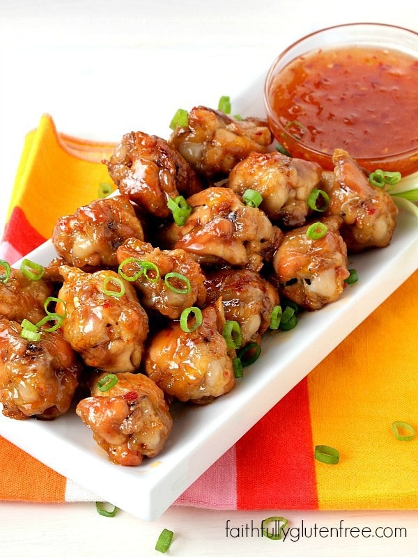 Plate full of chicken wings covered in a sweet and spicy sauce.