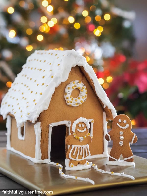 A gingerbread house decorated with silver and gold