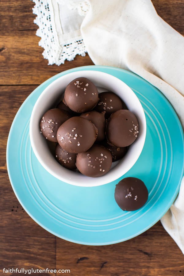 A blue plate with a bowl of chocolate truffles on it