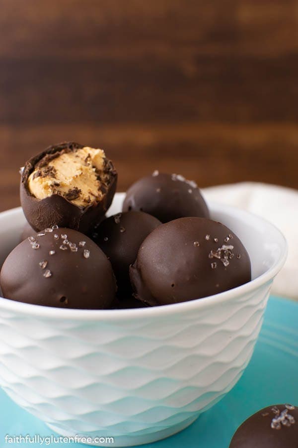 A bowl of truffles with one having a bite taken out of it