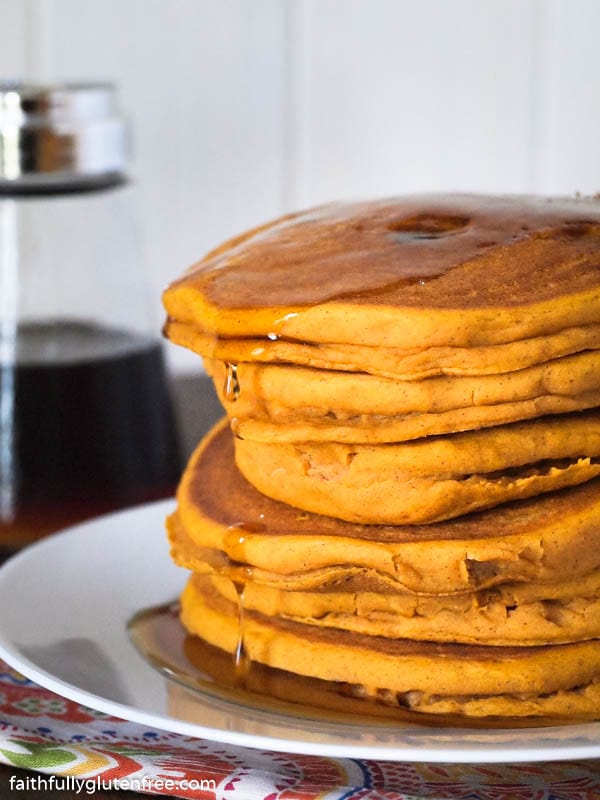 Stack of pumpkin pancakes dripping with syrup