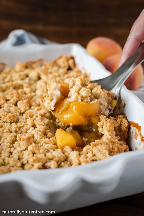 Peach Cobbler being spooned from a baking pan