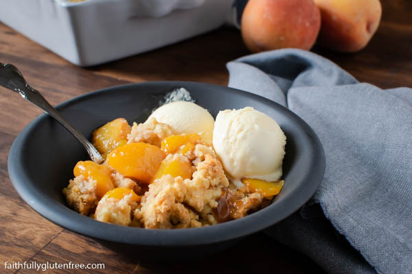a bowl of gluten free peach cobbler with ice cream