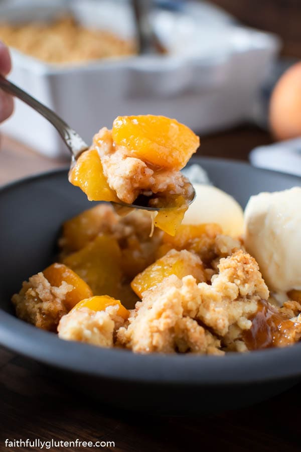 A spoon with homemade peach cobbler