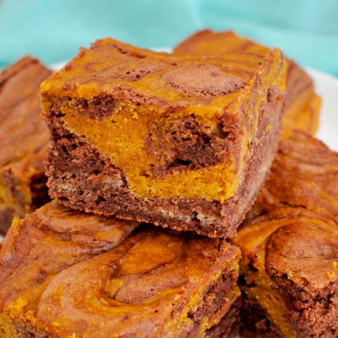 A stack of pumpkin swirl brownies on a plate