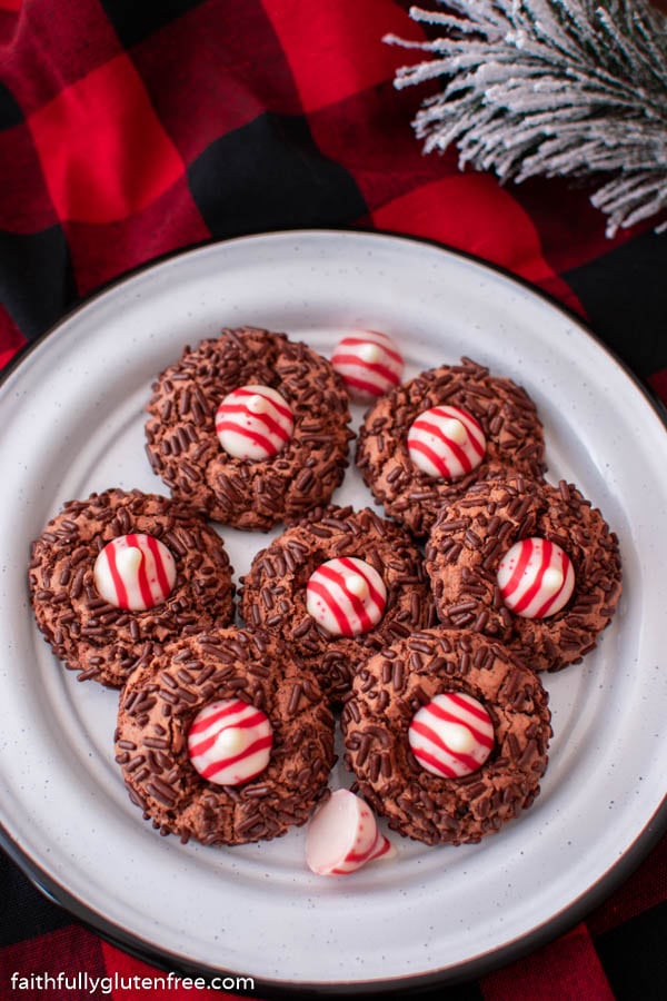 a plate of chocolate cookies with candy cane kisses