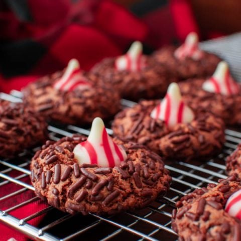 a cooling rack with chocolate candy cane kiss cookies